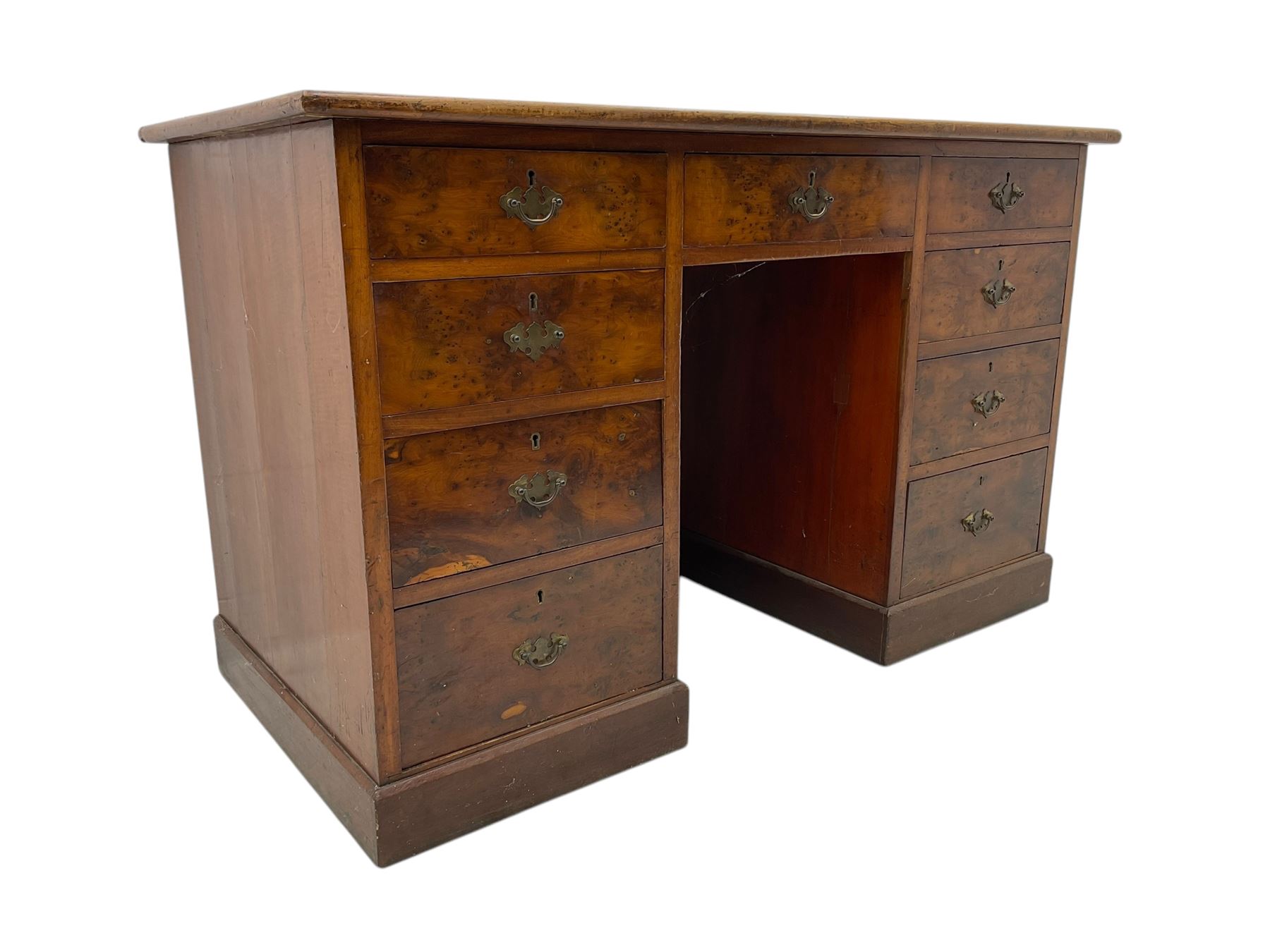 Late 19th to early 20th century walnut pedestal desk, rectangular top inset with red tooled leather writing surface, over a central frieze drawer flanked by two pedestals, each fitted with four graduated drawers with brass escutcheons and drop handles, the whole raised on a plinth base