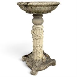 Weathered cast stone birdbath, the kylix shaped bowl with fluted body, raised on a fruiting foliate vine decorated fluted pedestal with upper knop and bird and fieldmouse motifs, shaped square base with scroll feet