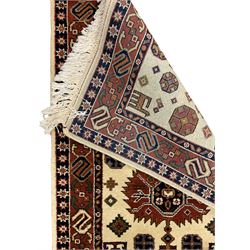 Persian design ivory ground rug, six lozenge medallions within a field of stylised animal and geometric motifs, the guarded border decorated with interconnected S motifs 