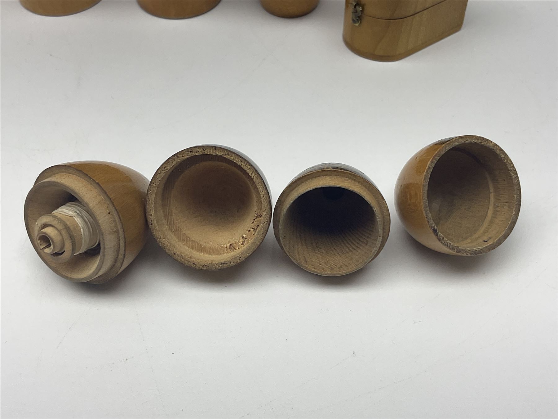 Collection of Mauchline ware relating to sewing, to include four ovoid shaped thimble cases, hinged lid thimble case and needle cases (12) 
