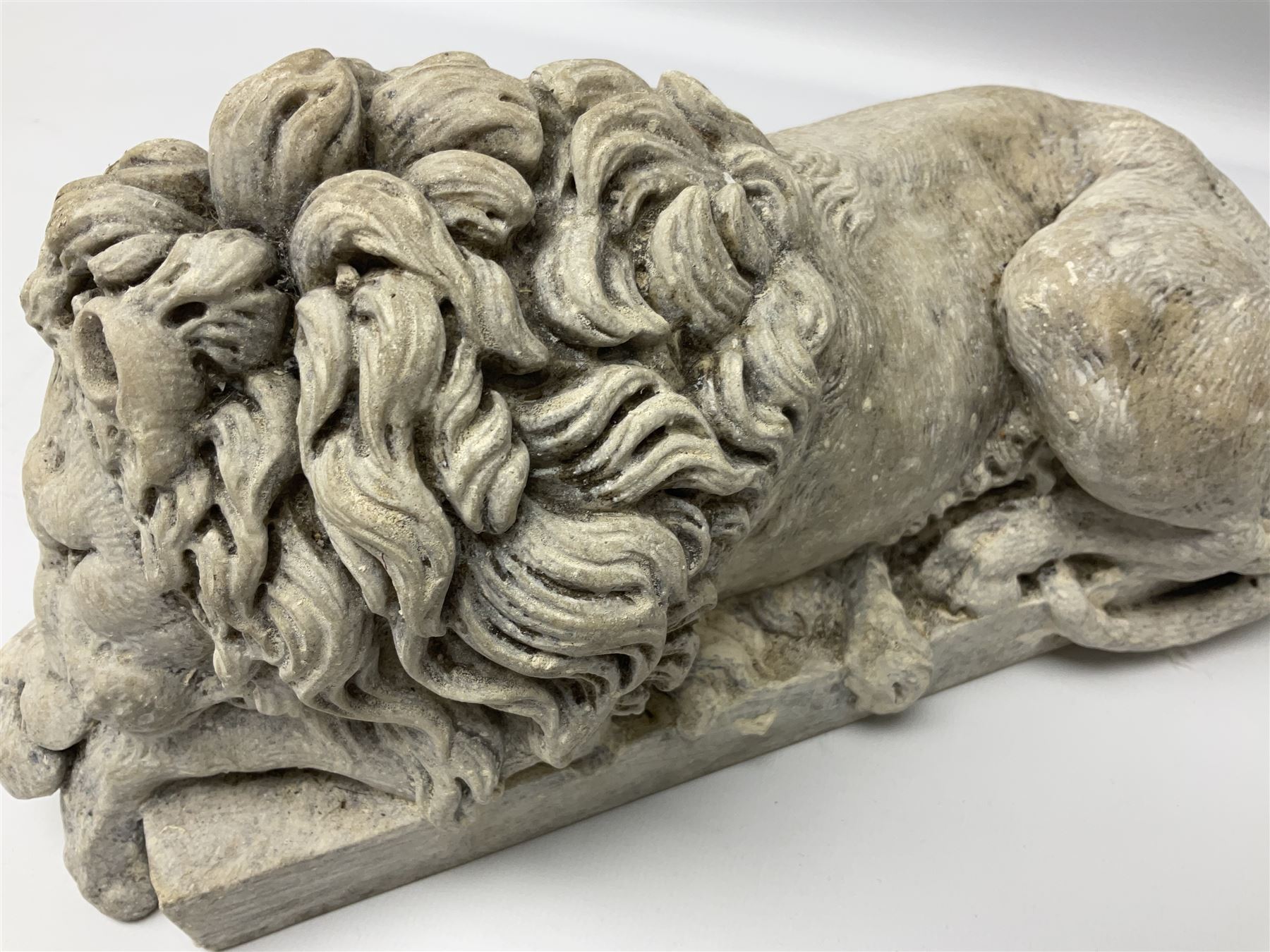 Two early 20th century reconstituted stone Grand Tour or Chatsworth House type lions after Antonio Canova, each modelled in recumbent pose upon a rectangular plinth, signed to plinth Dilettanti, each approximately L31cm