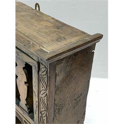 17th/18th century boarded oak wall hanging open shelf or glass cupboard, with projecting cornice above a single door with series of shaped splats, leaf carved upright decoration to sides, and central stretcher rail carved in relief with floral decoration above an open shelf, H62cm W52cm D17cm 