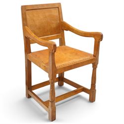 Mouseman - set of six (5+1) 1940s pre-war panel-back dining chairs, the raised backs with adzed panels, over seats upholstered in tan leather with studwork border, raised on octagonal turned baluster supports united by box stretcher, with carved mouse signature, by the workshop of Robert Thompson of Kilburn

Provenance: ordered directly from the Mouseman workshop in the 1940s before the outbreak of the war, the items were subsequently delivered after the end of war. 