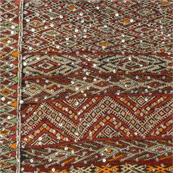 Moroccan Berber kilim rug, flatwoven with bands of geometric lozenge and chevron motifs in red, orange, ivory and green, decorated with applied sequins, fringed ends
