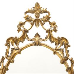 Rococo design giltwood and gesso wall mirror, oval plate within moulded frame, pierced cresting and apron, decorated with acanthus leaves, flowerheads and trailing foliage