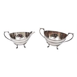 Early 20th century silver milk jug and sugar bowl, of circular form, with reeded girdle and capped scroll handles, each upon four pad feet, hallmarked William Aitken, Birmingham 191, H8.2cm