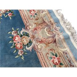Large Chinese blue ground woollen carpet, overall floral design, central oval medallion surrounded by scrolling floral decoration, wide border with decorated with floral bouquets 