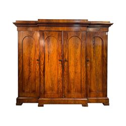 19th century mahogany break-fronted quadruple wardrobe, stepped and moulded projecting cornice over four arch panelled doors, moulded plinth base on blocks 