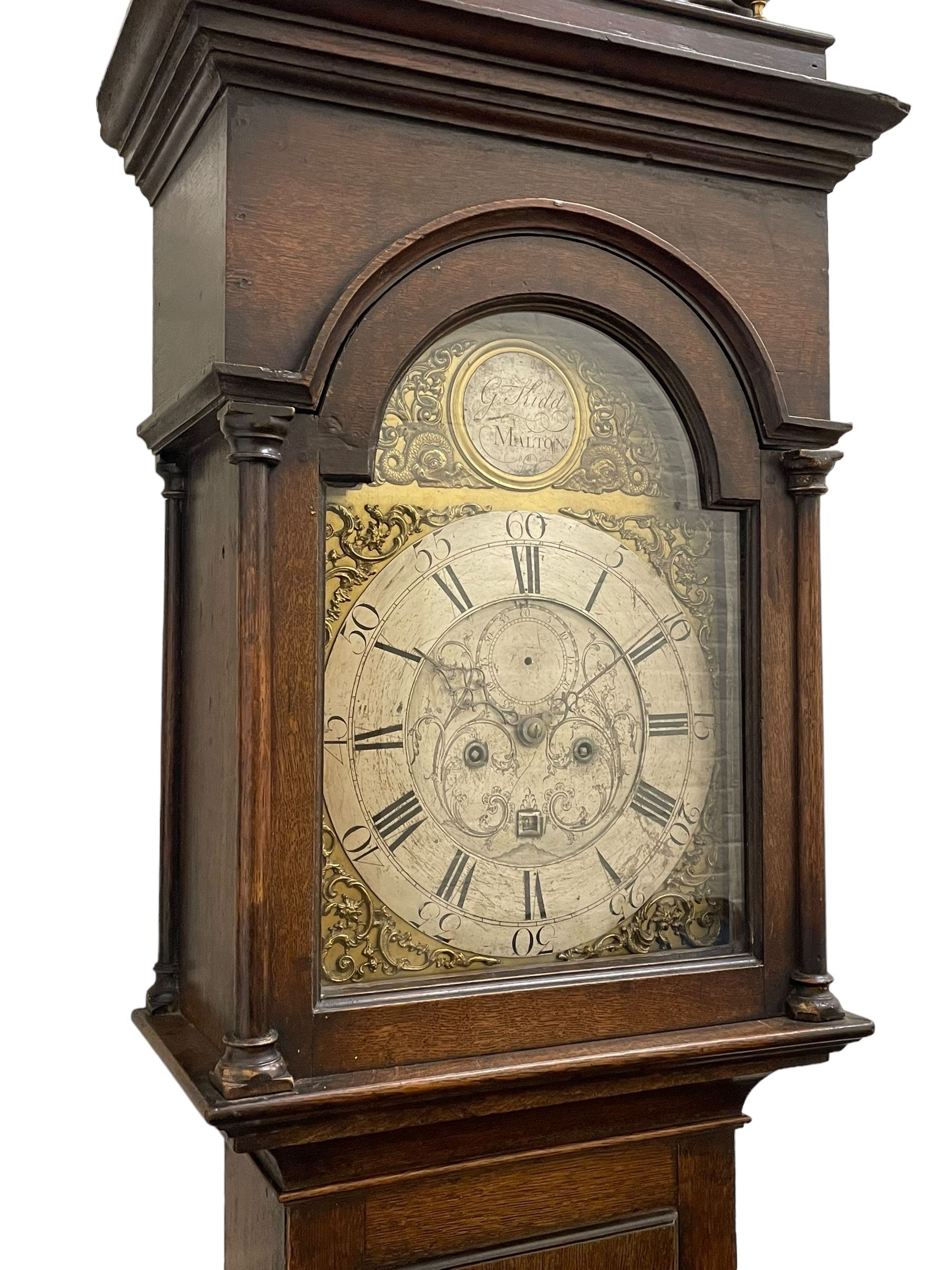 Gilbert Kidd of Malton (North Yorkshire) - late 18th century oak 8-day longcase clock c1780,  with a tall double caddy top and later brass ball and spire finials, break arch hood door beneath with attached pilasters and wooden capitals,  plain trunk with a long flat topped door, raised on a square plinth with applied skirting,  brass break arch dial with the makers name to the silvered boss in the break arch, engraved and silvered dial centre and chapter ring, with cast spandrels and matching steel hands, subsidiary seconds dial and square calendar aperture, dial pinned directly to a rack striking movement with a recoil anchor escapement, sounding the hours on a cast bell. With pendulum and weights.
The Kidd family were a prolific family of provincial clockmakers working in Malton from the mid 18th century until the early 19th century. Many of their clocks are simply signed 
