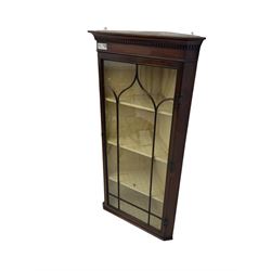 Early 20th century Georgian design mahogany wall-mounted corner display cabinet, projecting cornice with dentil frieze over astragal glazed door enclosing three fabric-lined shelves