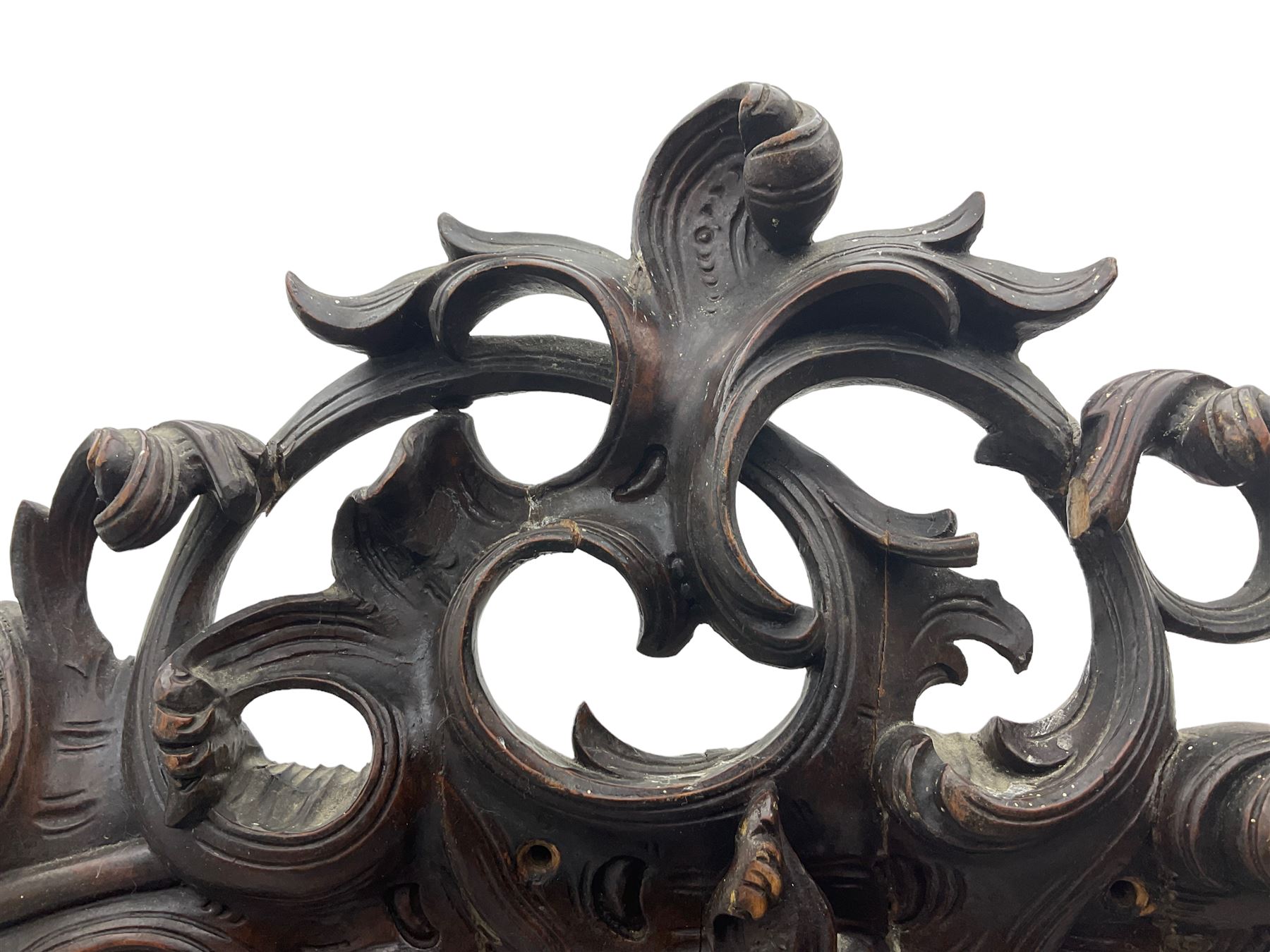 Early 20th century Italian walnut armoire wardrobe, the pierced and scrolling pediment carved with acanthus leaf detail, flanked by two scrolling cartouche with matching corbels below, the two panelled doors with applied carved rinceaux slips, with a central spiral turned upright, enclosing single shelf and hanging rail, raised on scroll feet