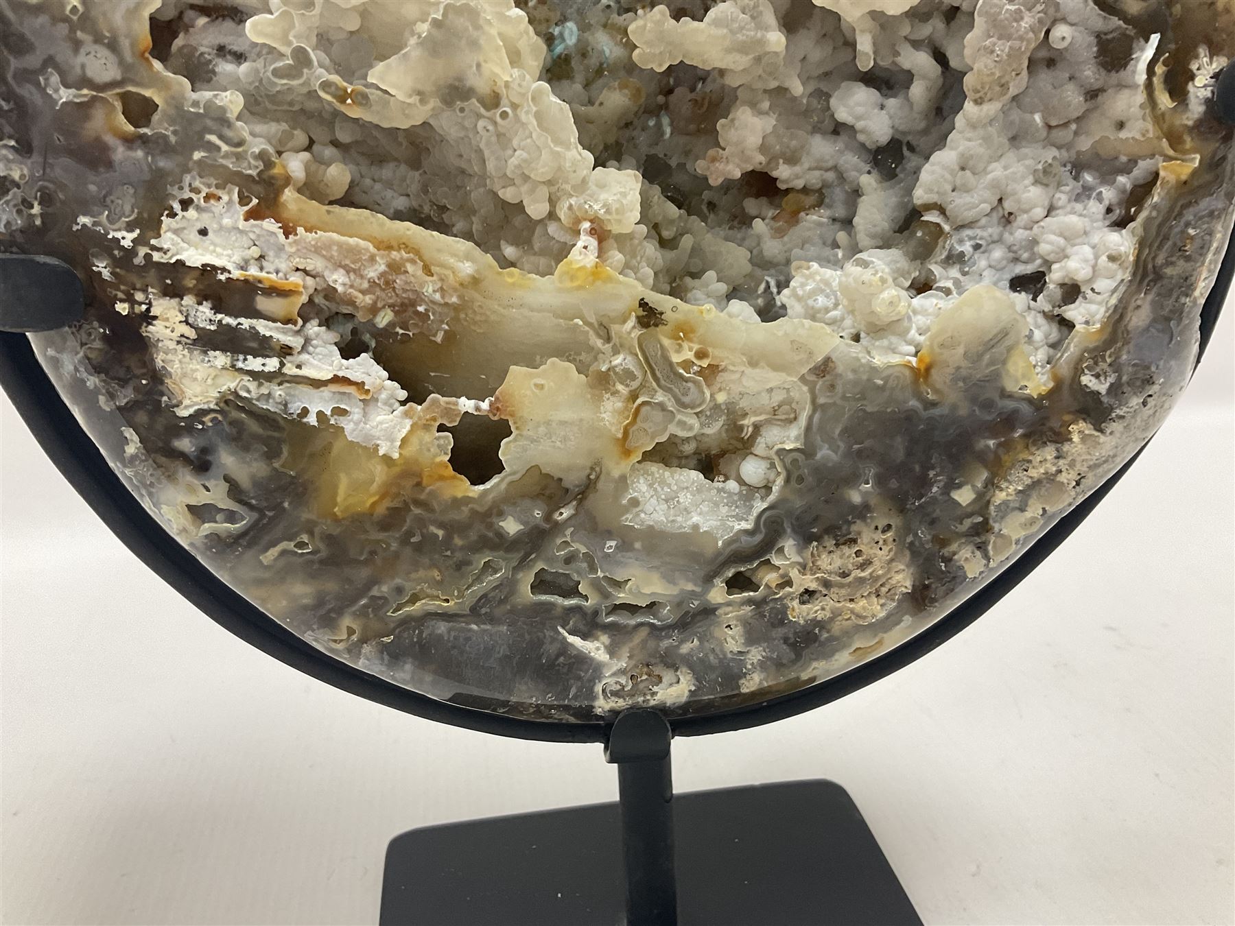 Large agate geode with quartz crystals to the centre, upon a metal stand, H35cm 