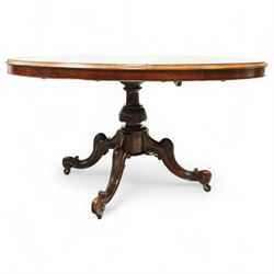 Victorian 19th century burr walnut oval centre table, hinged top above a carved pedestal supported on a scrolled carved quadruped base