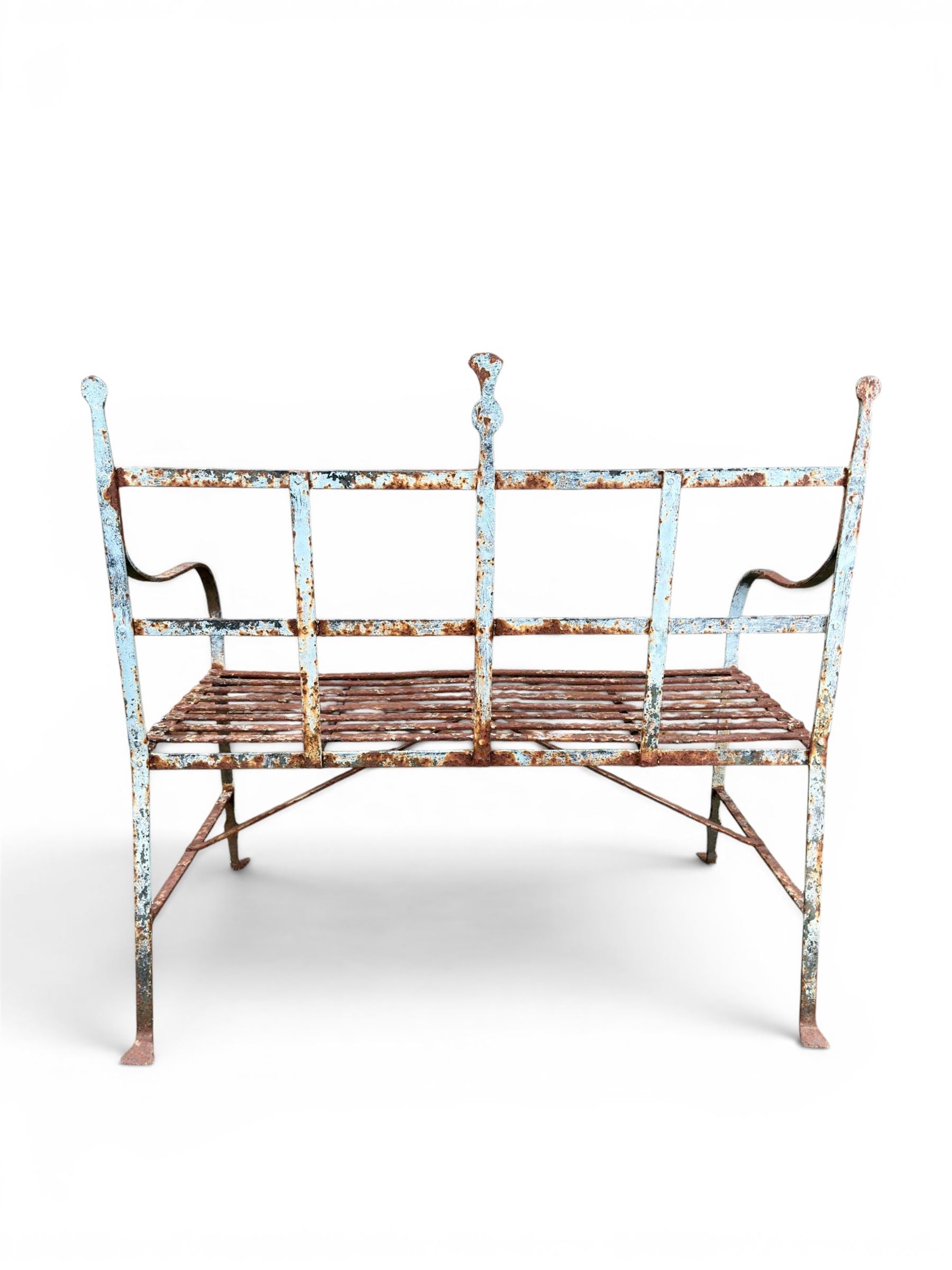 Regency period wrought iron strapwork garden bench, cresting rail with central Scottish thistle motif and flanking pediments, in distressed blue painted finish