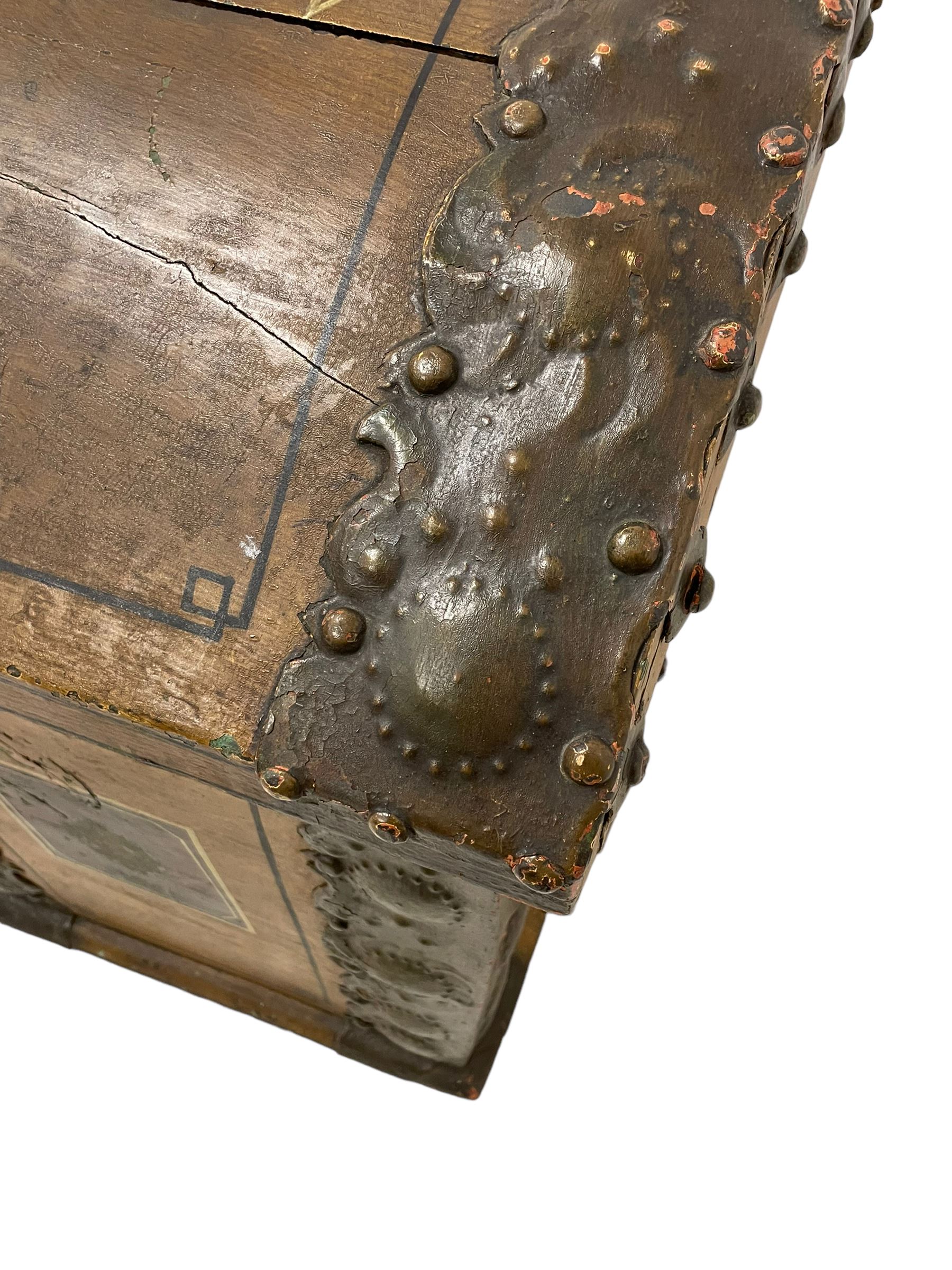 19th century painted oak sea chest, hinged dome top enclosing small compartment, bound by shaped and pressed metal strapwork, scumbled finish to resemble oak and painted with small vignettes depicting portraits and landscapes within panels, fitted with large wrought metal carrying handles, the front inscribed 'H.J.S. 1870' 