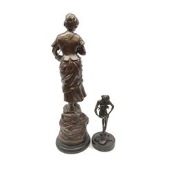 After Mestais, a bronzed spelter figure, modelled as a female figure holding a basket of fish, with signature, upon circular ebonised base, overall H57cm, together with a bronze modelled as a nude female figure, signed to base Noel, overall H25cm. 
