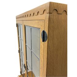 'Mouseman' oak display cabinet on cupboard, raised cabinet enclosed by two lead glazed doors, adzed oak top over double panelled cupboard, fitted with ironwork and carved with mouse signature, by Robert Thompson of Kilburn