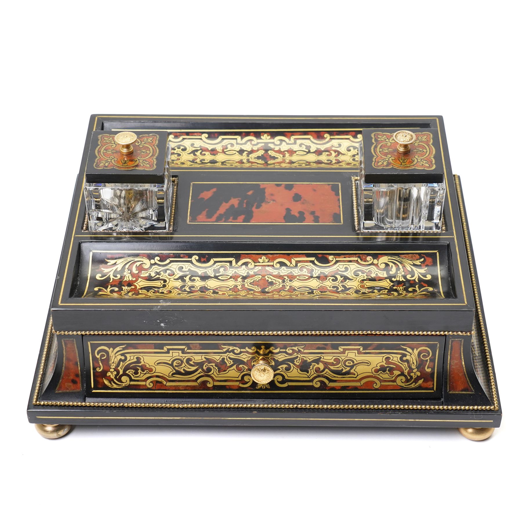 Mid 19th century Boulle inkstand in cut brass and tortoiseshell with beaded decoration with two pen trays and two inkwells on a single drawer base and compressed bun feet W32cm 