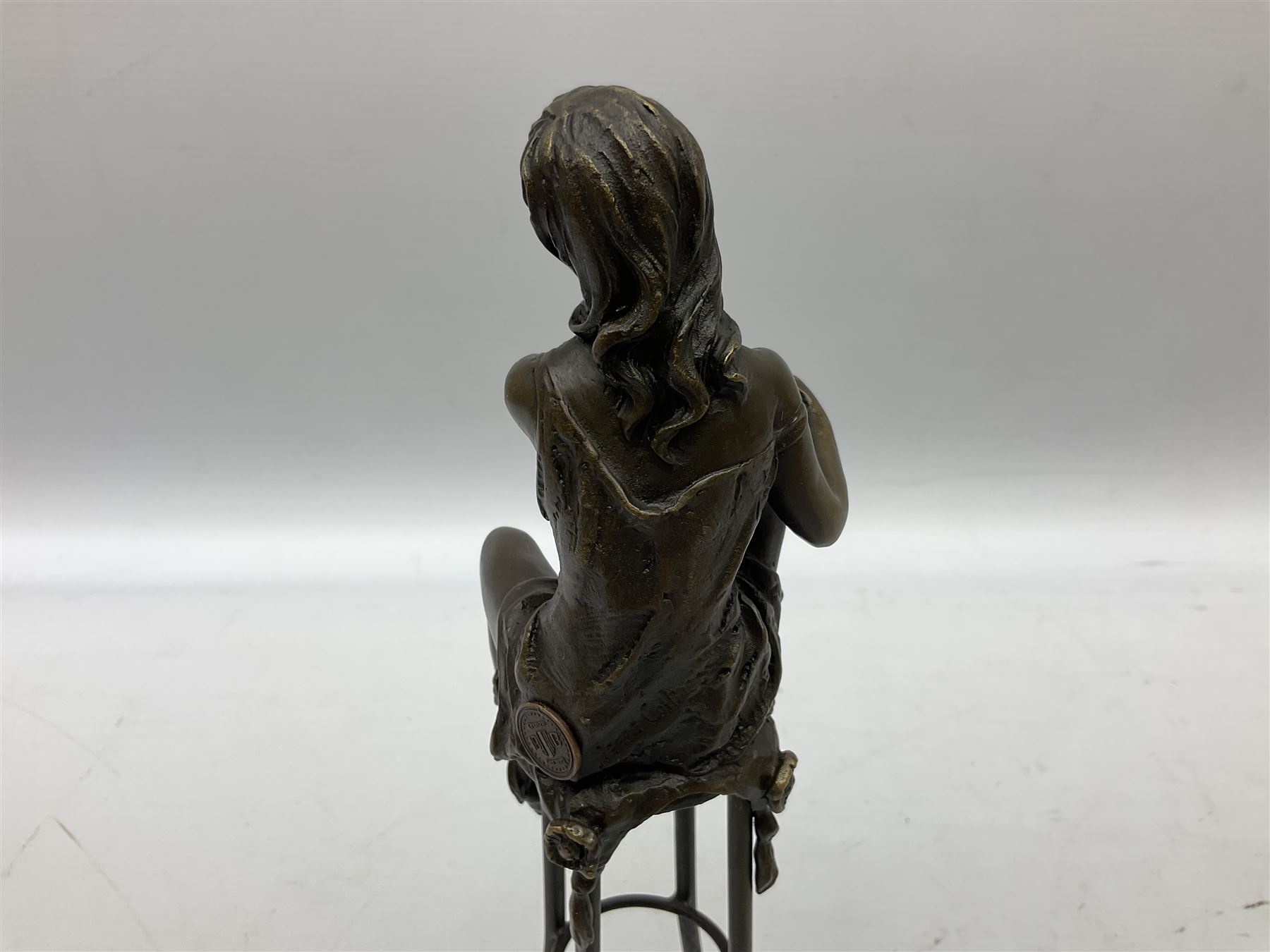 Art Deco style bronze modelled as a female figure, holding her knee, seated upon a chair, after 'Pierre Collinet', H28cm