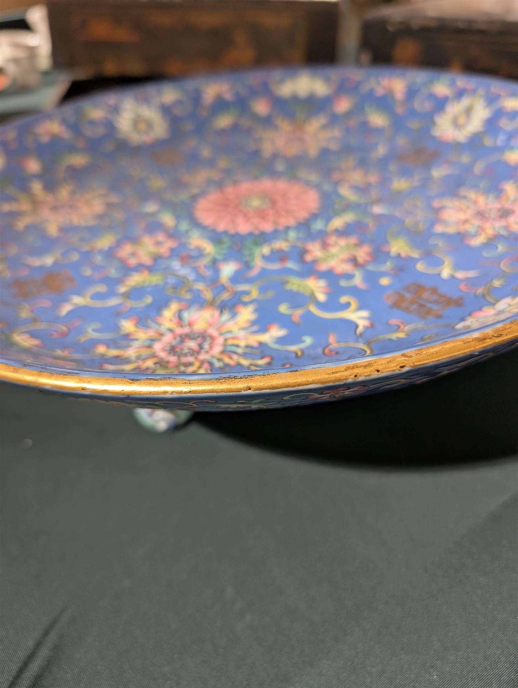 20th century Chinese footed bowl, of circular form, decorated in polychrome enamels with flowers and foliage on a cobalt blue ground, upon three grotesque mounted feet, with character marks beneath, H13cm, D38cm