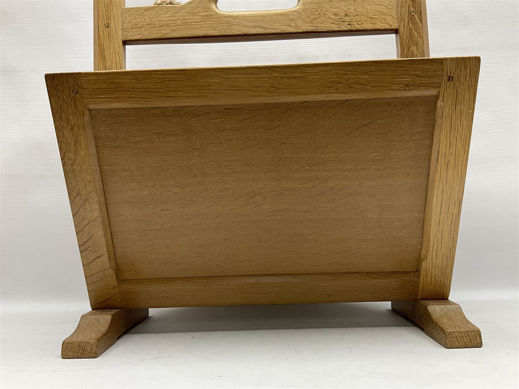 Mouseman - oak magazine rack, the top rail pierced with handle and carved with mouse signature, octagonal supports with two panelled and splayed sides, on sledge feet, by the workshop of Robert Thompson, Kilburn 