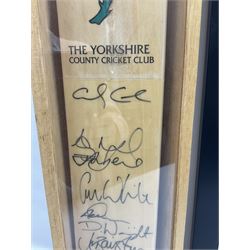 Two signed Yorkshire County cricket bats, bearing signatures including Anthony McGrath, Jacques Rudolph, Michael Vaughn and Matthew Hoggard, etc, both within glazed presentation boxes, box H86.5cm, together with a framed Darren Gough signed presentation print by Gary Keane