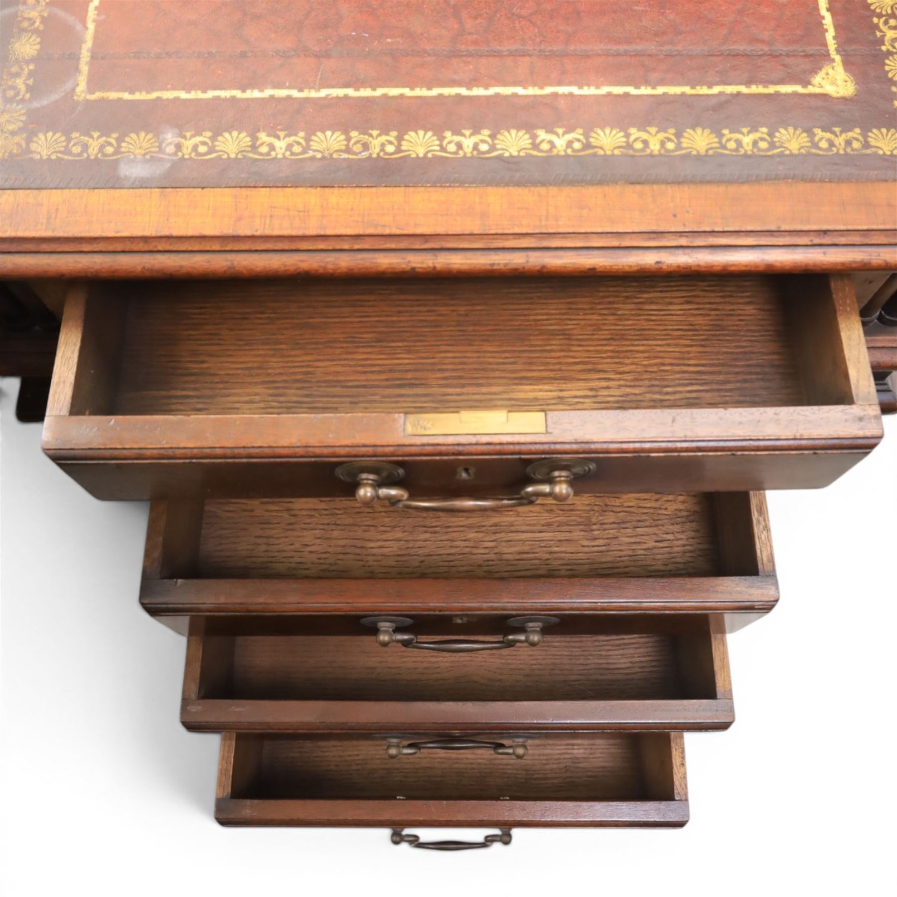 George III style large mahogany reverse breakfront partners desk, red tooled leather writing surfaces crossbanded and moulded edges, flanked by ring-turned cluster columns three frieze drawers with brass swan neck handles, raised on large pedestals with faux drawer fronted cupboard and three graduated drawers, supported on carved ogee feet decorated with C-scrolled and acanthus leaves