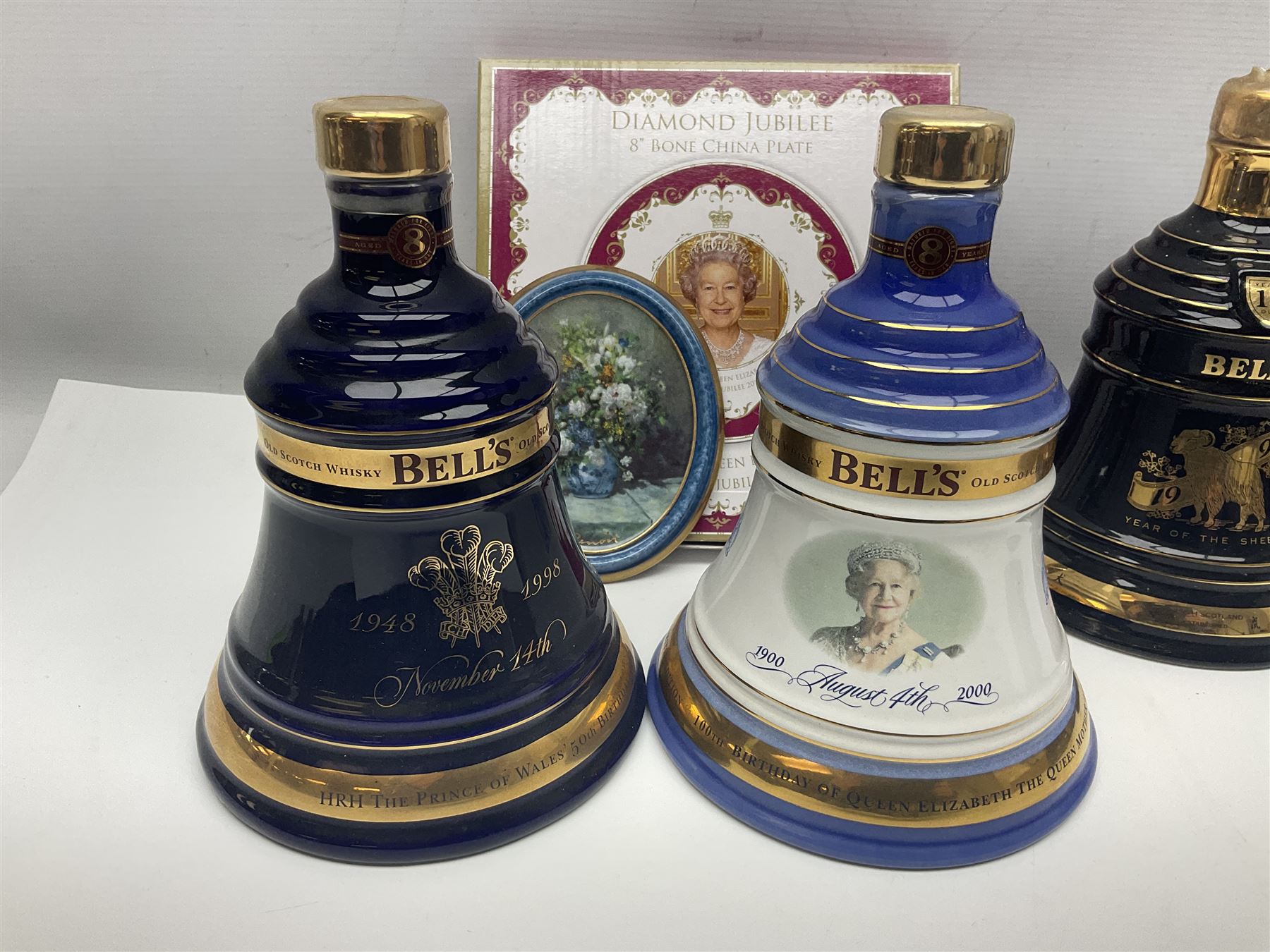 Bells, Scotch whisky, in seven Wade ceramic decanters, to include 50 year reign HM Queen Elizabeth II, Ninetieth Birthday of the Queen mother, 1991 year of the sheep, etc, together with two empty decanters and other items 