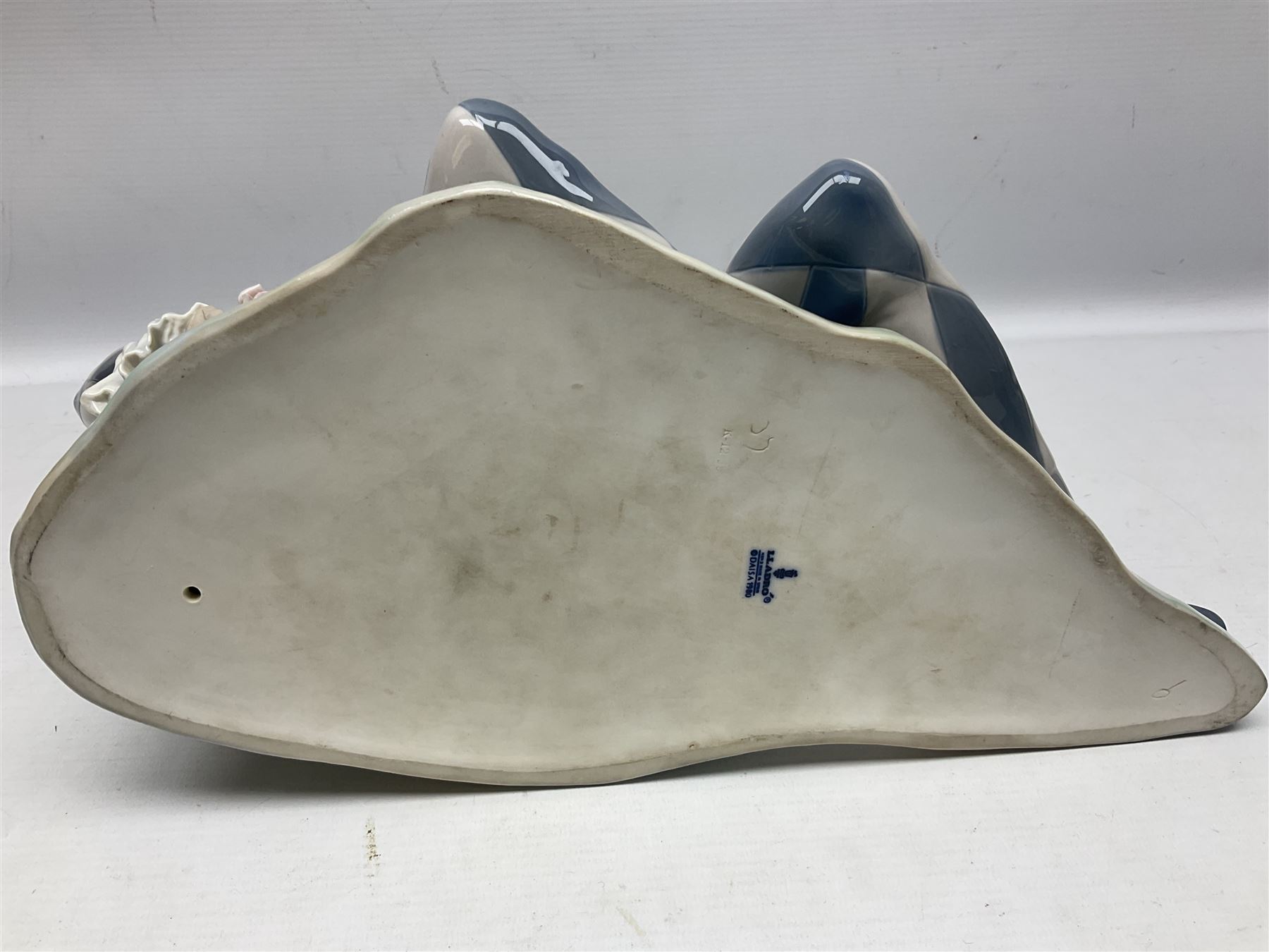 Lladro figure, Harlequin Reclining, modelled as a recumbent harlequin, no 5128, Sculpted by Salvador Furio, year issued 1982, year retired 1987, H28cm 