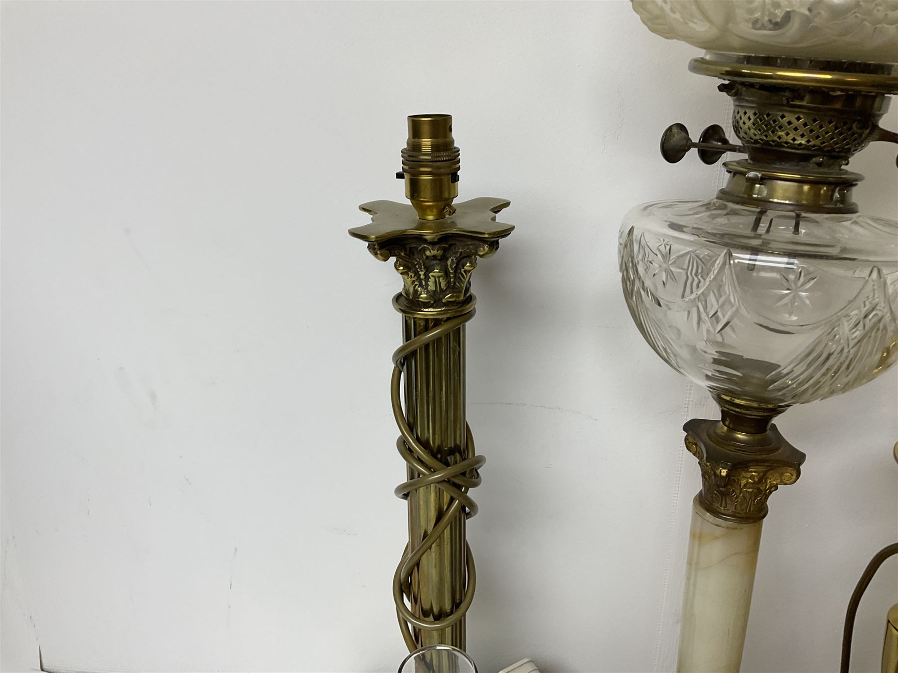 Oil lamp with frosted floral shade and cut glass reservoir, upon cast brass and marble base, together with a cast brass Corinthian column table lamp, pair of brass table lamps and a composite metal figure of a violinist 