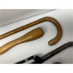 Collection of walking sticks including cane example with silver cap and collar