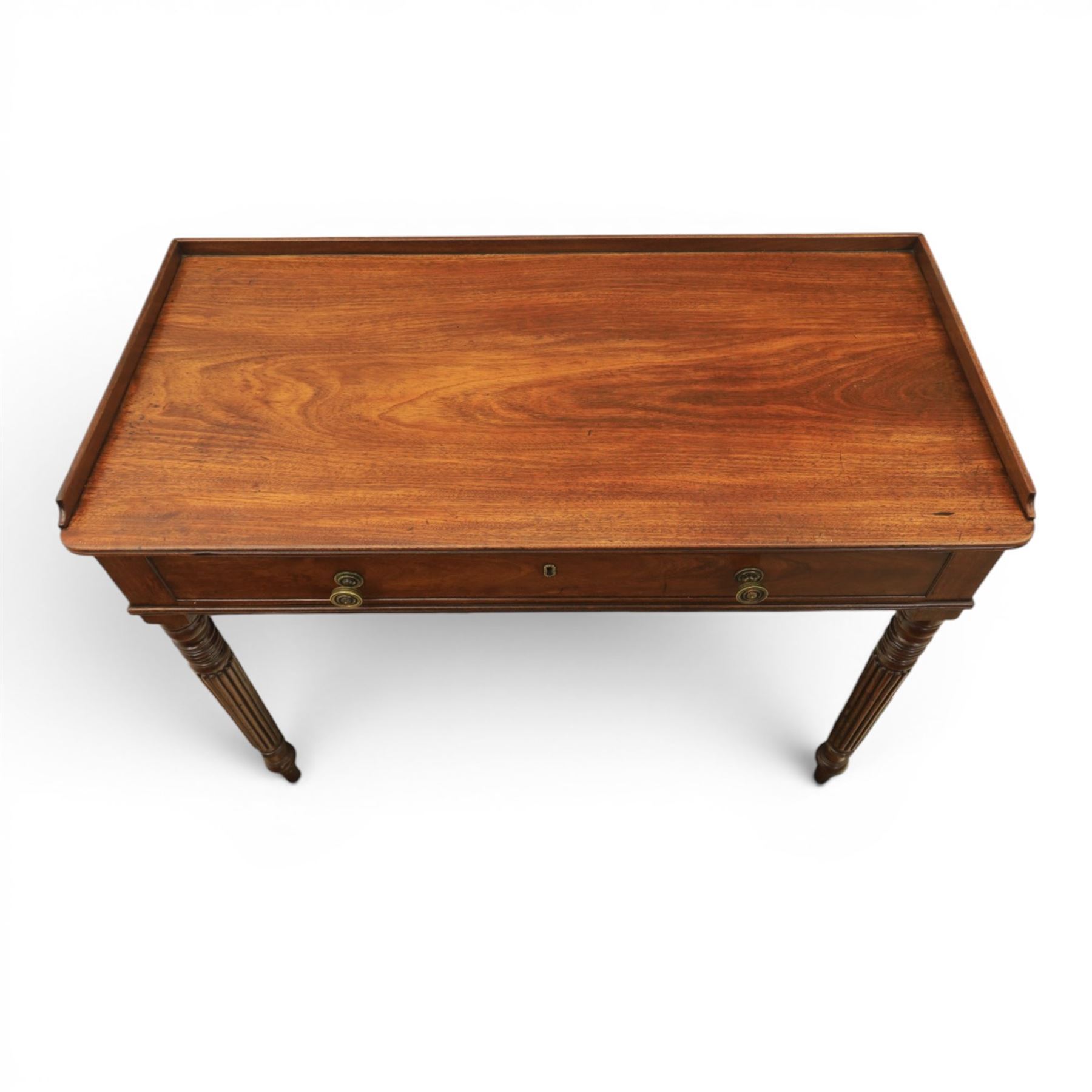 Early 19th century mahogany dressing table, rectangular top with three quarter gallery, frieze drawer with two brass knobs, stamped 'Gillow', raised on turned and reeded supports 