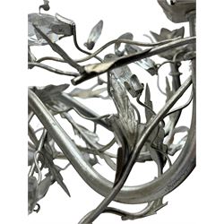India Jane - silver finish metal chandelier, modelled with scrolling vines and leaves, embellished with faceted glass drops, fitted with six candle sconces, and wired for electricity