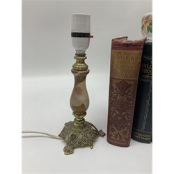 Oil lamp with ornate metal base and painted glass reservoir, together with two table lamps and books 