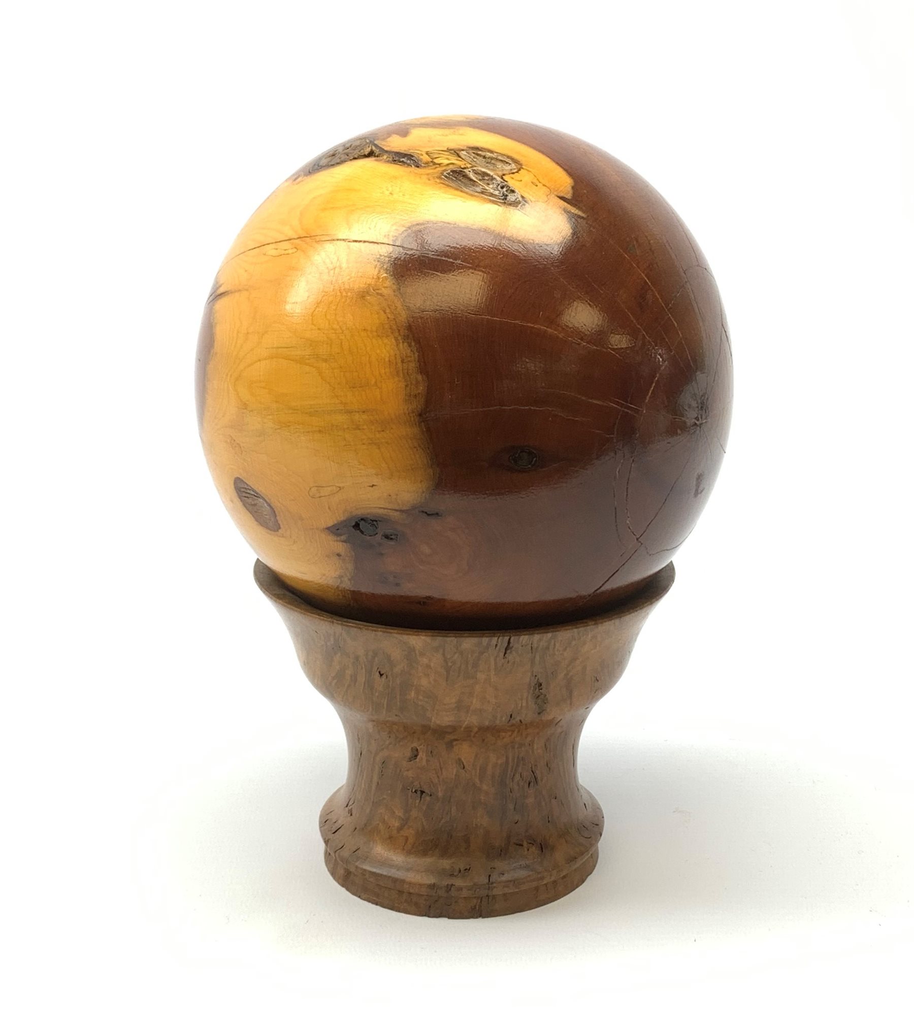 A yew wood sphere, together with a burr cedar stand, overall H22cm.