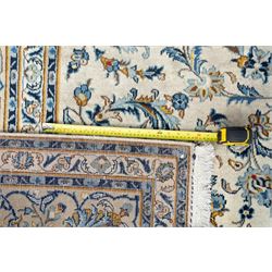 Central Persian Kashan hand-knotted carpet, ivory field profusely decorated with an all-over scrolling vine, palmette, and lotus design in shades of soft blue, pale gold, and green within floral borders