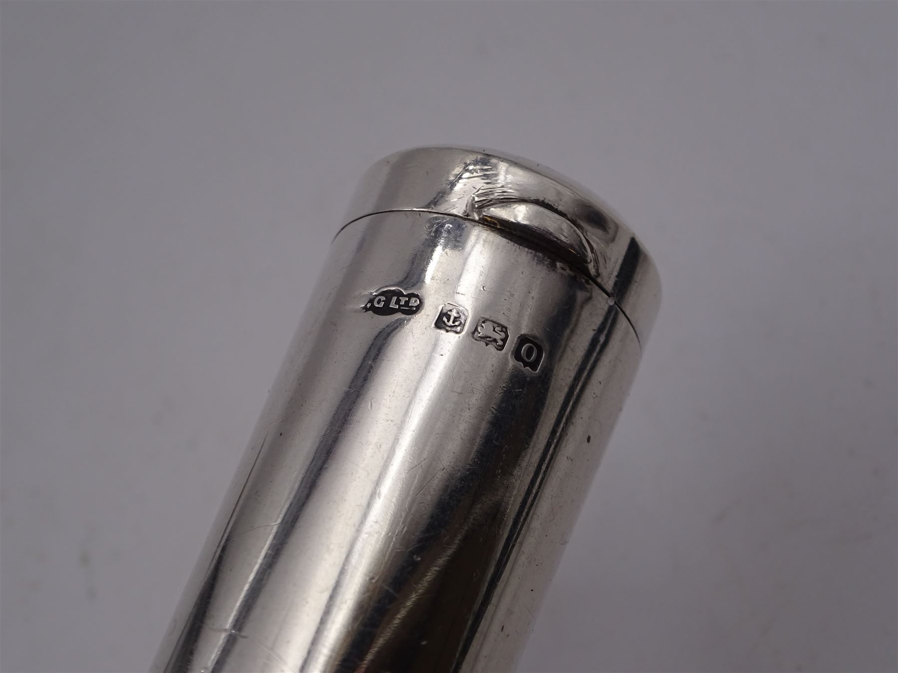 Early 20th century silver tape measure, of circular form, engraved with monogram, inscribed Chesterman Sheffield England to edge, hallmarked James Chesterman & Co, Sheffield 1912 together with a 1930s silver cheroot holder case, hallmarked Joseph Gloster Ltd, Birmingham 1938 containing a cheroot holder with hallmarked 9ct gold collar 