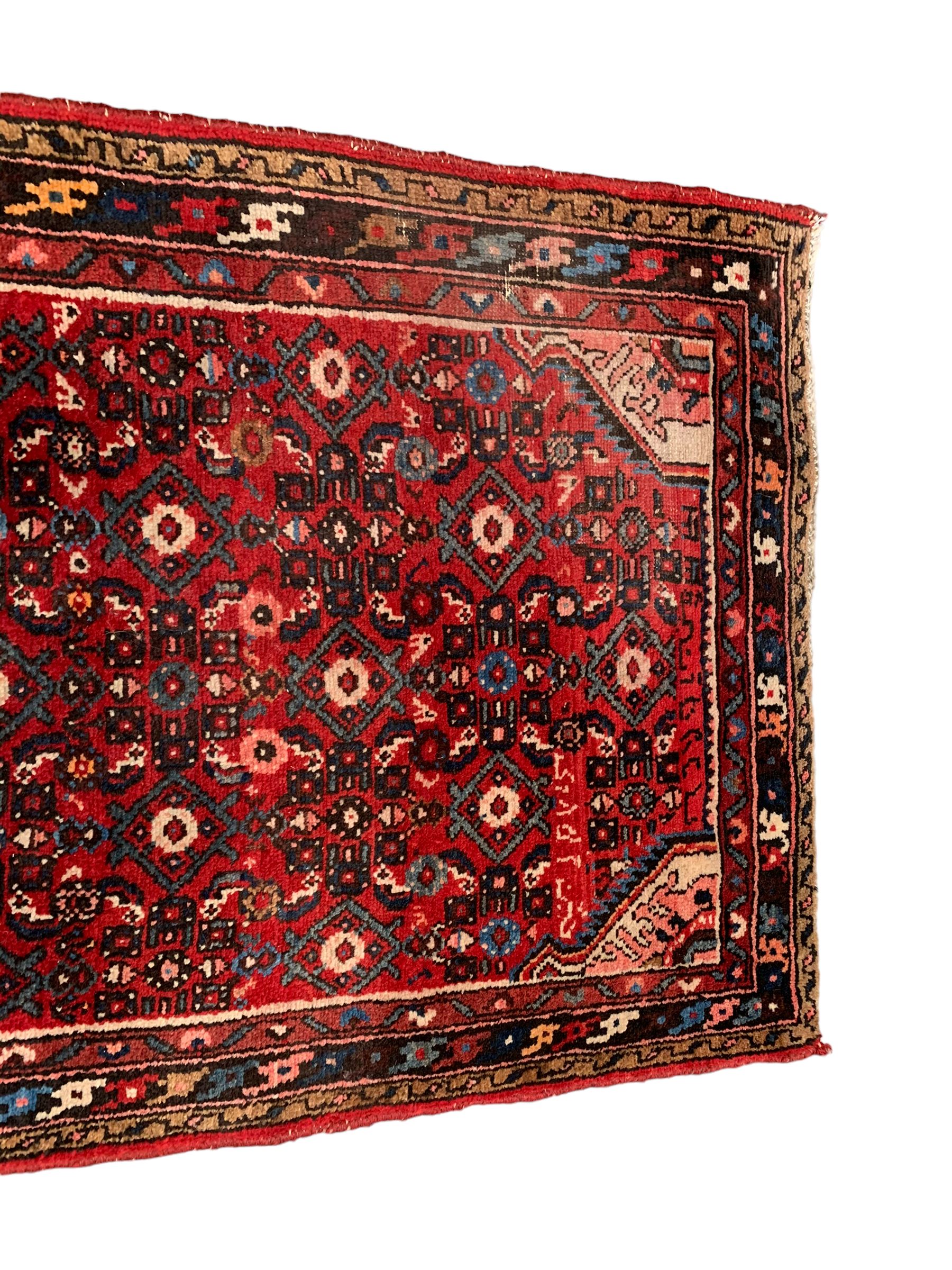 Persian crimson ground runner, the field decorated with Herati motifs,  three-band border, the main band decorated with repeating flowerheads 