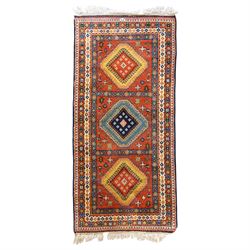 Caucasian Kazak vermillion ground rug, the sectioned field decorated with three geometric ...
