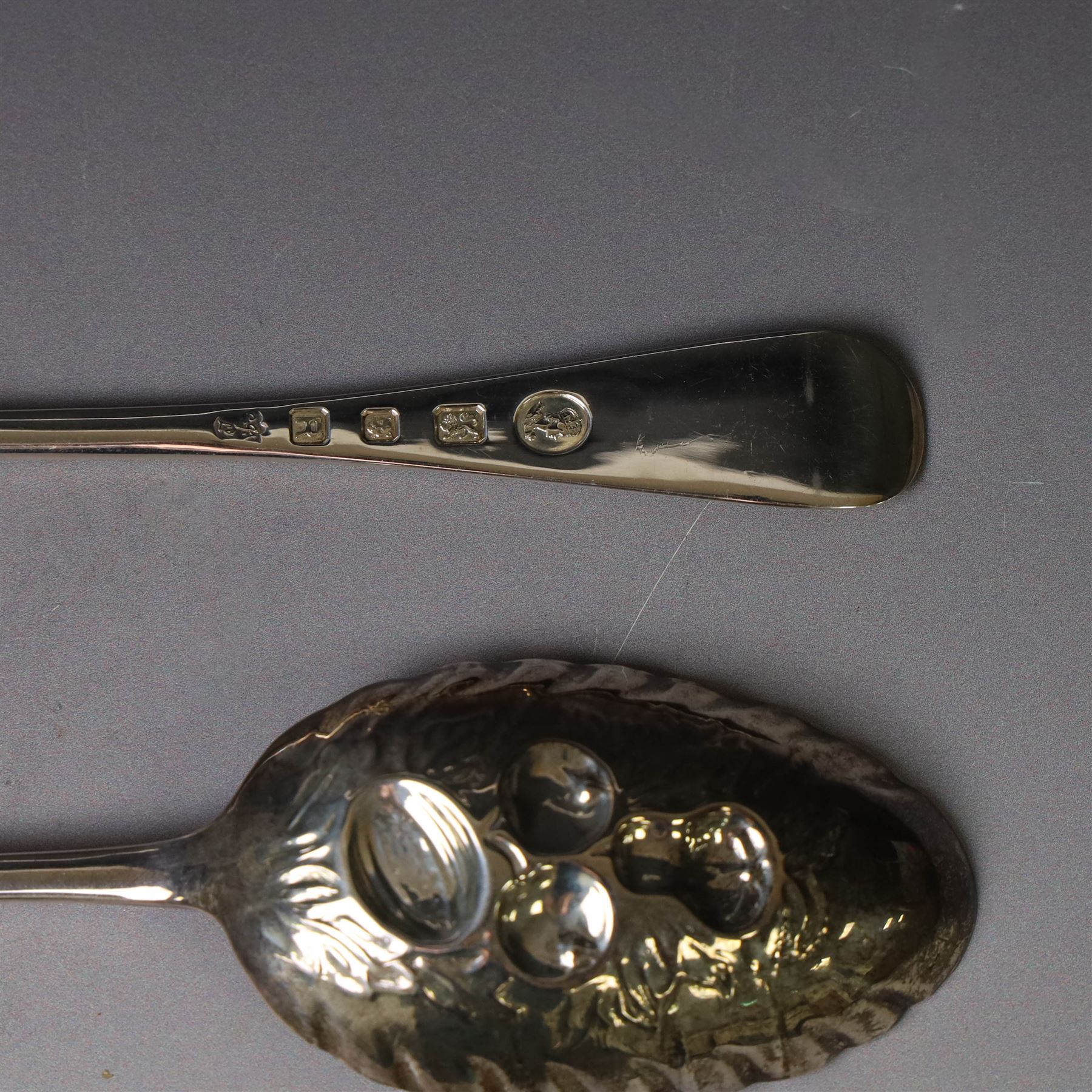 Mid 20th century silver berry spoons, each with gilt bowls embossed with fruit, with Queen Elizabeth II Coronation hallmark for C J Vander Ltd, London 1952, L22cmcm