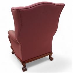 Georgian design mahogany framed wingback armchair, upholstered in rouge fabric, on ball and claw feet with foliate cartouche decoration 