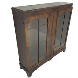 Early 20th century mahogany bookcase, foliate carved edge over banded frieze, fitted with two astragal glazed doors, on bracket feet