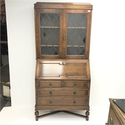 Early 20th century bookcase on bureau, two lead glazed doors above single fall front enclosing fitted interior, two short and two long drawers, cup and cover support joined by stretchers, W95cm, H198cm