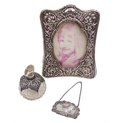 Victorian photograph frame, embossed with C scrolls and floral decoration, with easel style support verso, together with a silver mounted cut glass scent bottle and a modern silver 'Gin' decanter label, all hallmarked, frame H17cm