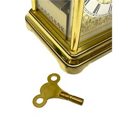 A 20th century brass cased Kieninger (German) chiming mantle clock with a break arch top and three glazed panels, polished sheet brass dial with applied  brass fretwork and a silvered chapter ring, Roman numerals, minute track, steel serpentine hands and seconds dial, three-train spring driven 8-day movement with Westminster, St Michael and Whittington chimes on 8 gong rods, 9 jewel lever platform escapement.  With key. 