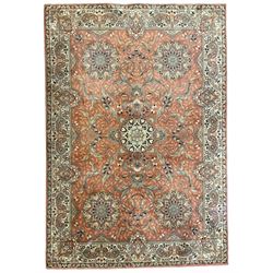 Persian design peach ground carpet, central floral medallion surrounded by scrolling foliage, decorated all over with stylised plant motifs, floral design repeating border