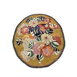 20th century wool oval rug, mustard ground and decorated with flower heads, with pink and green outer bands