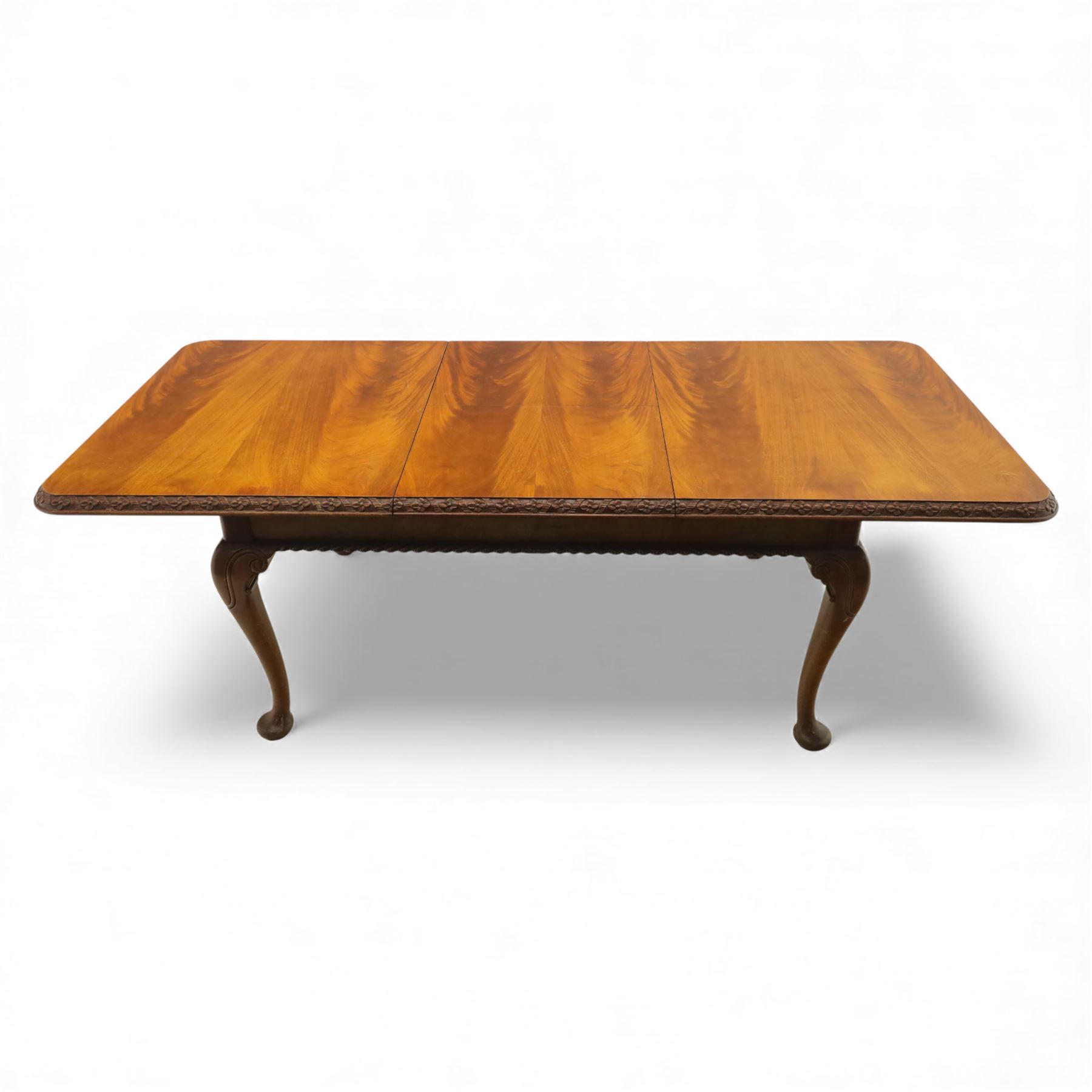 Queen Anne design walnut dining suite, comprising a rectangular dining table with carved moulded edge and rounded corners, raised on cabriole legs terminating in pad feet, together with a set of six matching dining chairs, each with shaped splat back, leather upholstered seat and cabriole supports (Extends to 230cm)