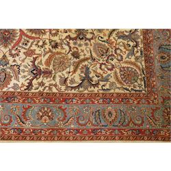 Persian Isfahan ivory and crimson ground rug, the busy field with central floral pole medallion surrounded by foliate motifs and stylised palmettes, the indigo guard line with repeating scrolling plant motifs