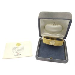 Omega ladies18ct gold manual wind wristwatch, round brilliant cut diamond bezel, on integrated 18ct gold bracelet, London 1964, boxed with guarantee dated 1965